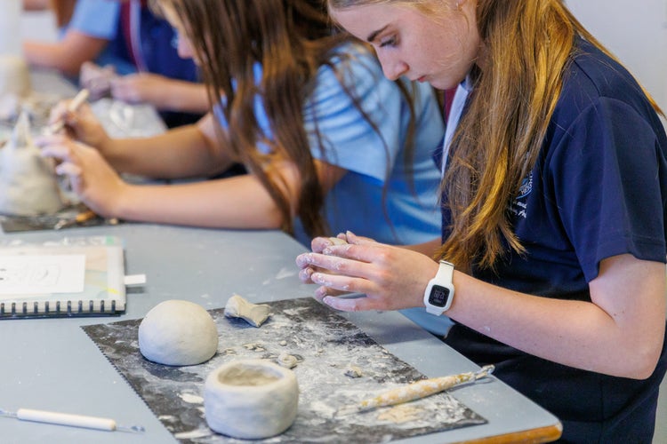 Student making clay pottery